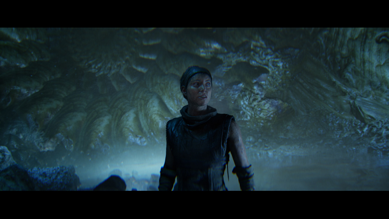 Senua looks around in a glowing cave.