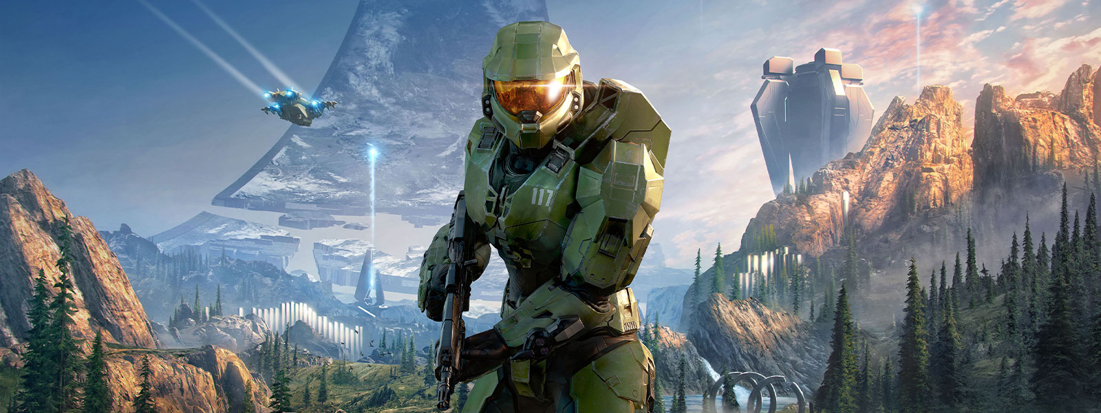 Master Chief holding an assault rifle with the ring in the background