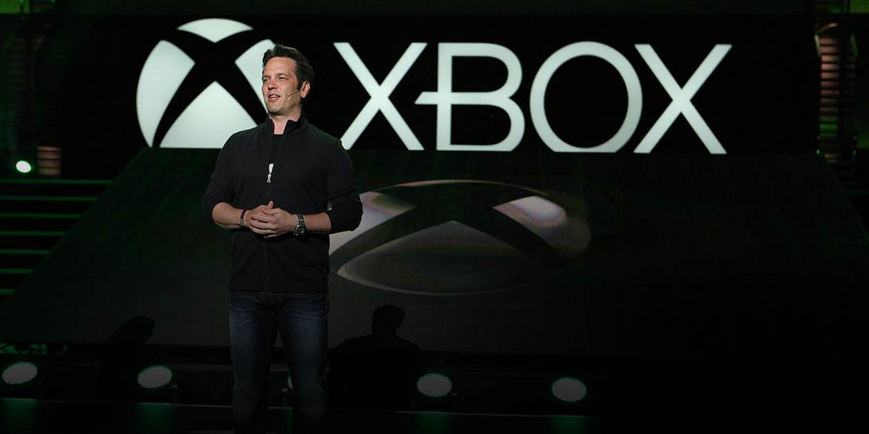 Xboxin johtaja, Phil Spencer, seisoo lavalla Xbox-logon edessä