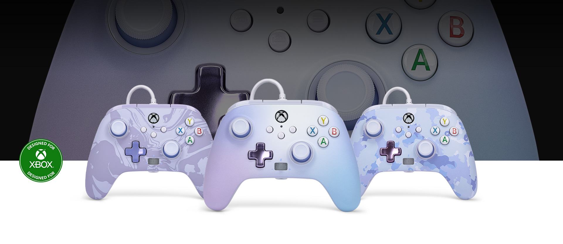 Logo Conçu pour Xbox, manette rêve pastel à l’avant de manettes tourbillon violet et camouflage violet à côté