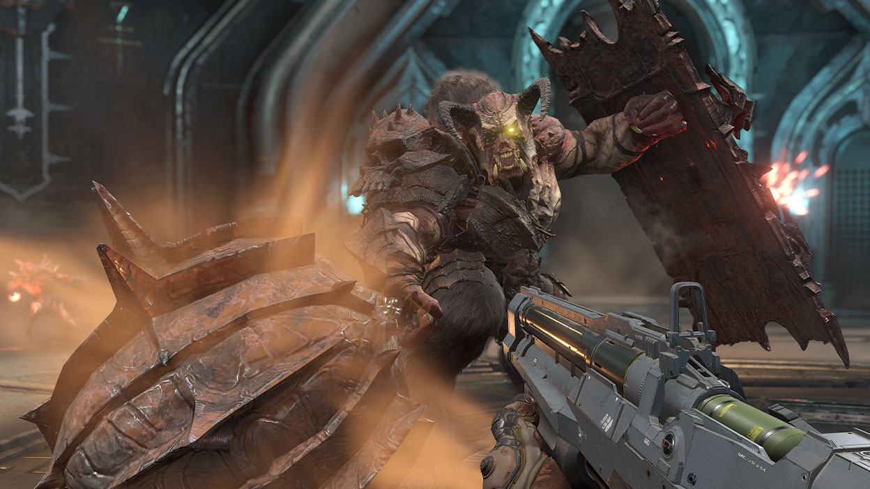 Jättimäinen sarvipäinen hirviö hyökkää kohti pelaajaa, jolla on ase valmiina.