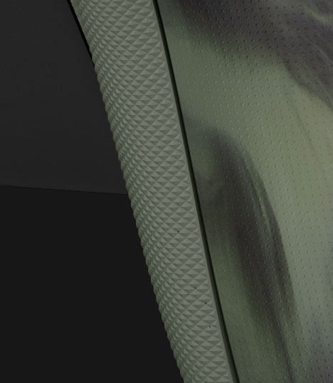 Close-up van de achterkant van de Xbox draadloze controller – Nocturnal Vapor Special Edition met de met rubber beklede grips met groen ruitpatroon op de achterkant van de behuizing.