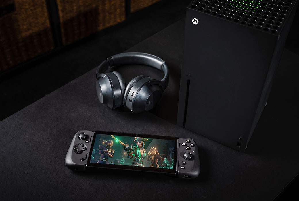 Razer Edge and headphones laying next to each other on a flat surface.