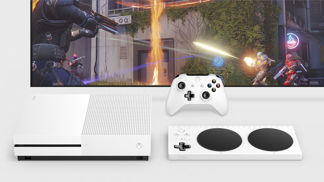 Top down view of the Xbox One S and Xbox Adaptive Controller in front of a TV and a white Xbox Controller