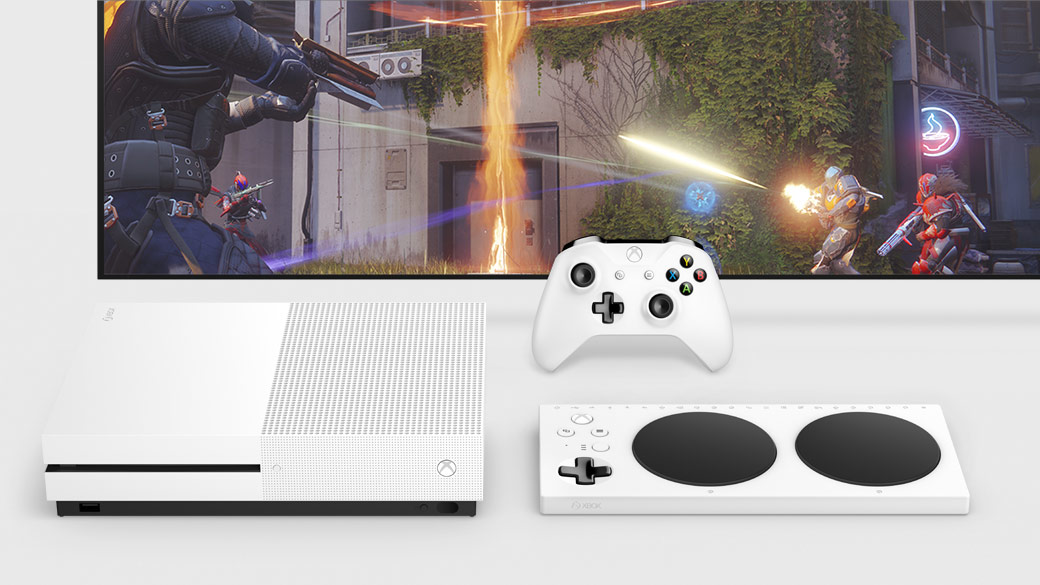 Vista desde arriba de Xbox One S y el Xbox Adaptive Controller delante de un televisor y un Mando Xbox blanco