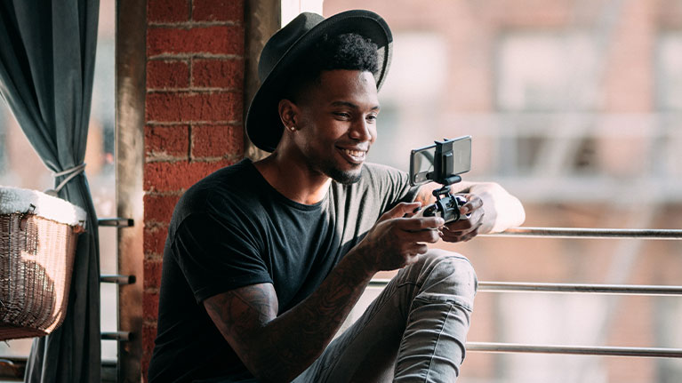 A person gaming on their mobile phone using an Xbox controller and clip