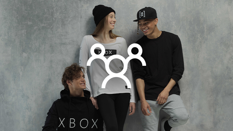 A group of smiling people wearing XBOX Official Gear, overlaid with an outline of three human figures