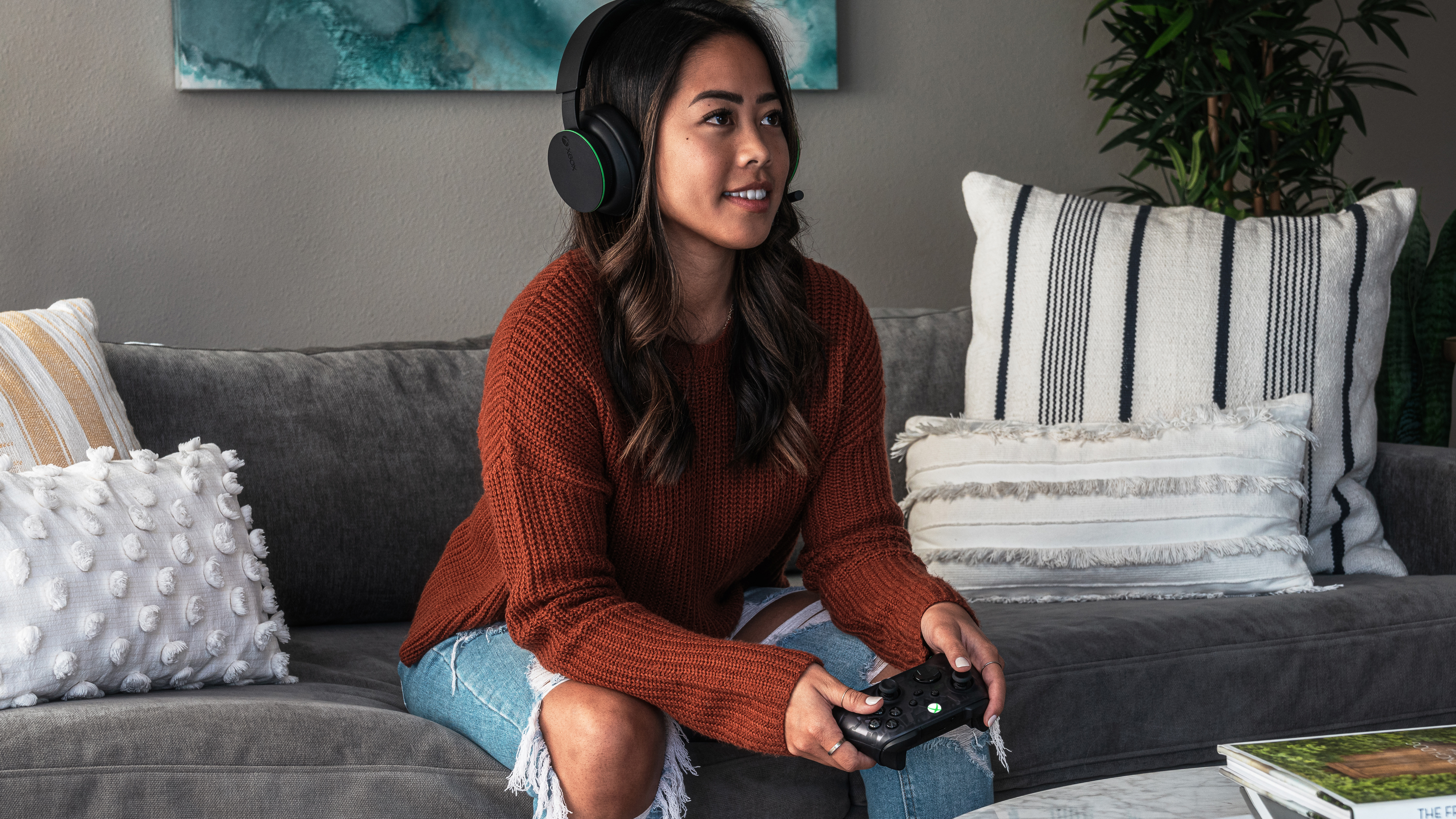 Personne assise sur un canapé avec un casque et une manette Xbox