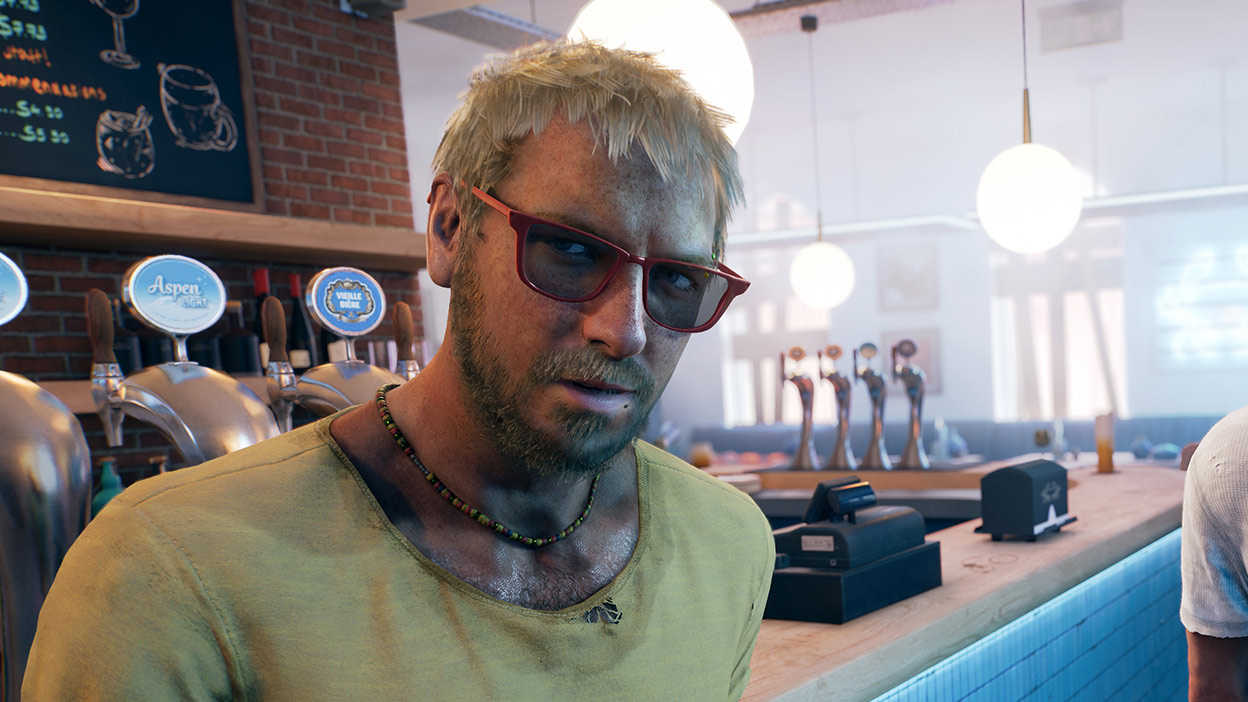 Un homme en chemise jaune et lunettes de soleil s’appuie sur une table de bar.