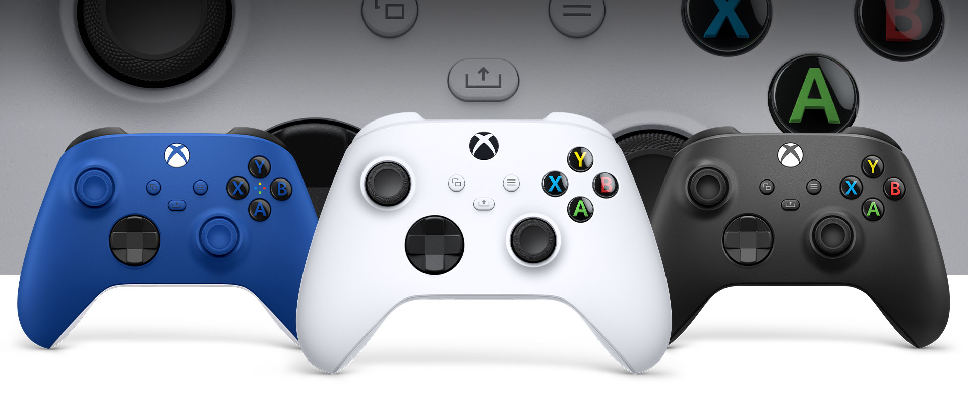 Xbox-controller i robothvid foran med kulsort Xbox og controllere i stødblå ved siden af den