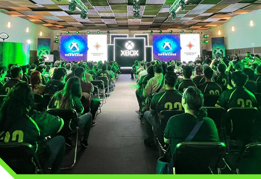 Uma watch party do Xbox ao vivo em uma grande sala de conferências.