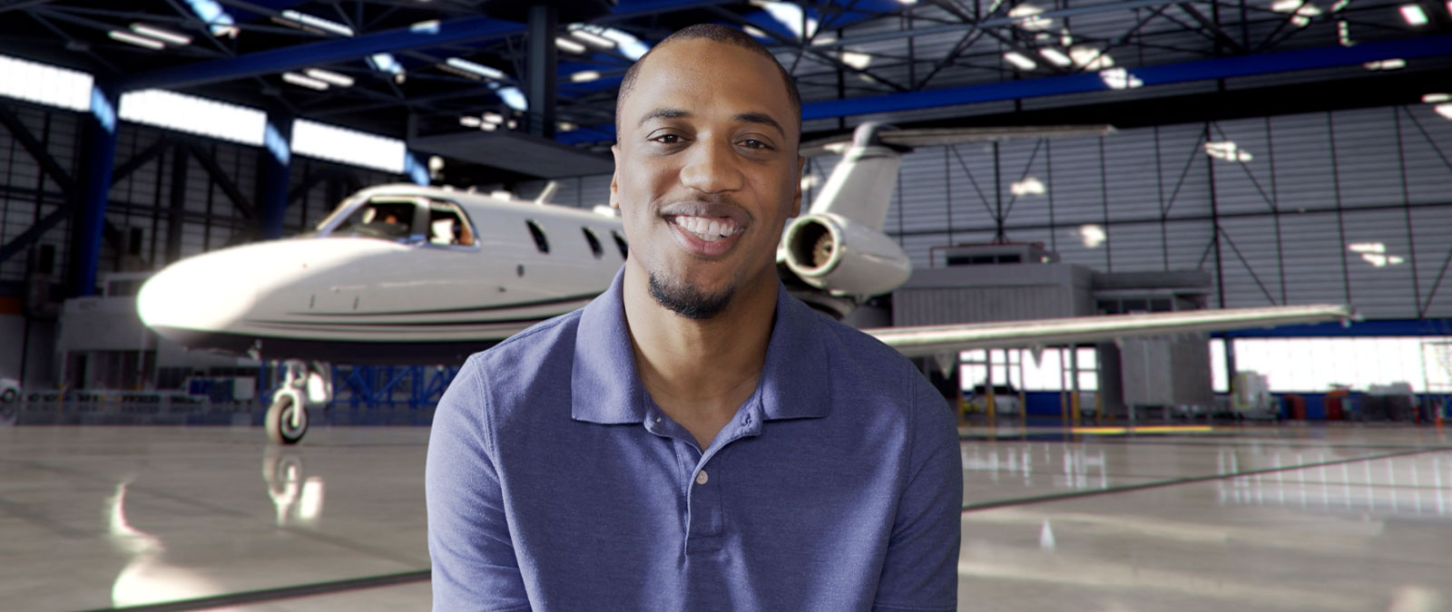 Acepilot in blue shirt talking in front of a plane