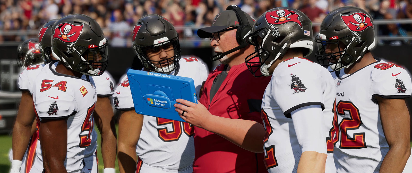 Un grupo de jugadores de Tampa Bay Buccaneers reunidos alrededor de su entrenador.