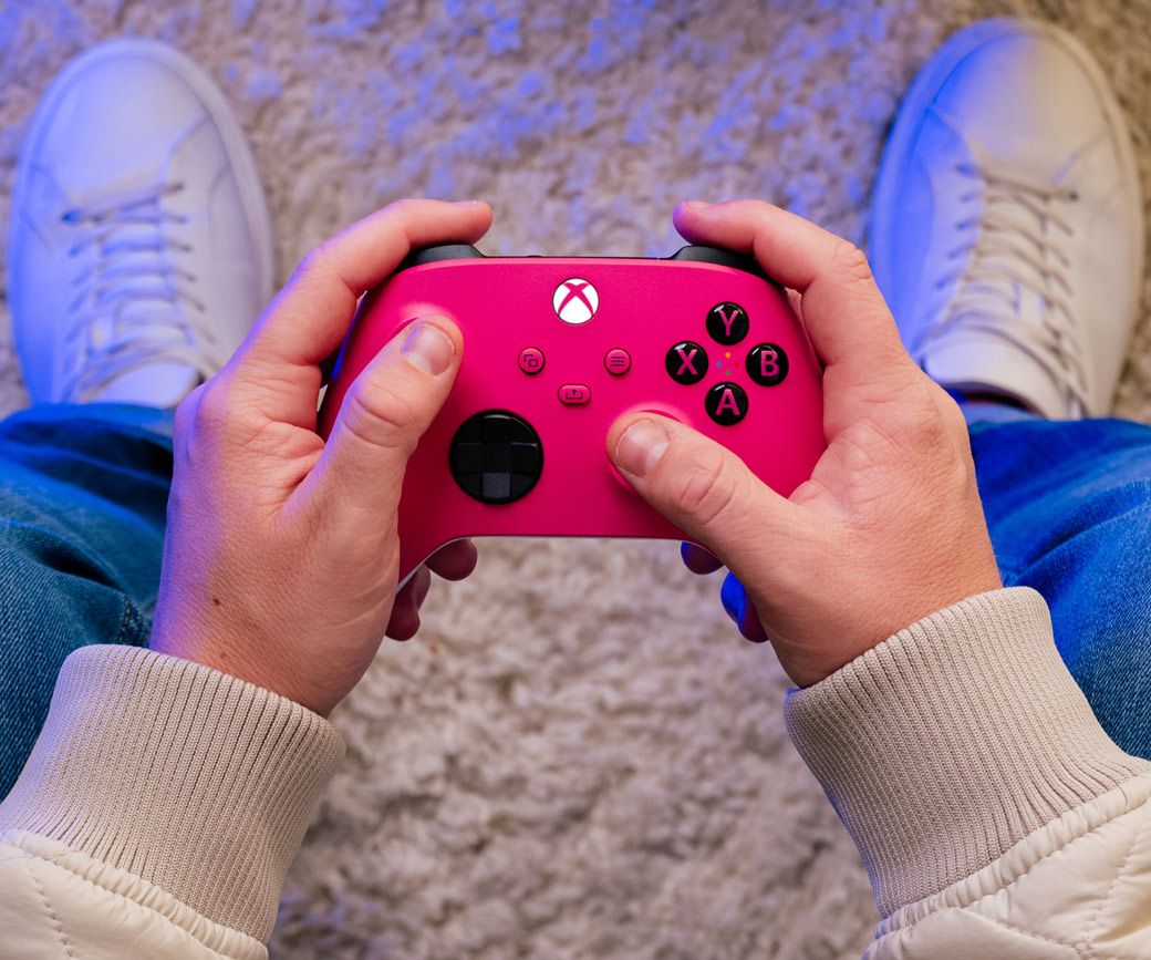 Top view of someone holding the Xbox Wireless Controller - Deep Pink while seated