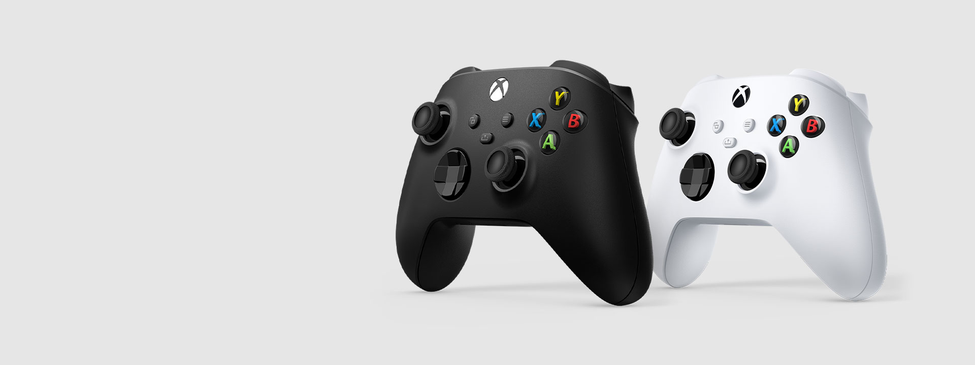 En svart och en vit trådlös Xbox-handkontroll sedd från sidan