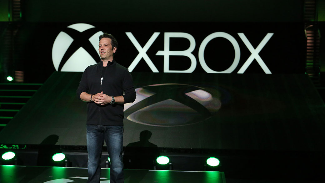 Phil Spencer, directeur de la branche Xbox, se trouve sur une scène devant le logo Xbox