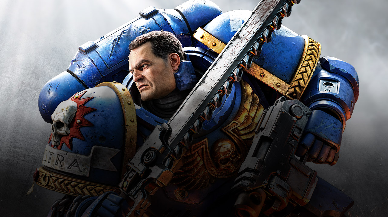 A Space Marine in blue armor holds a chainsaw and his gun.