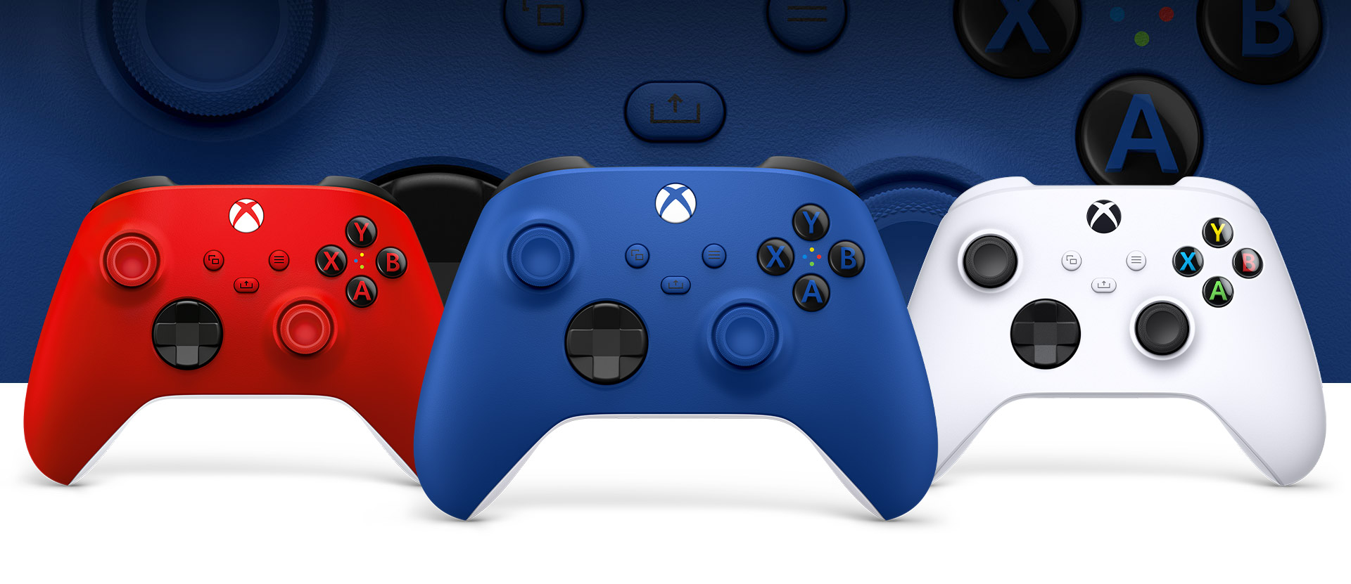 Геймпад Xbox в сине-голубом цвете Shock Blue на переднем плане, на фоне геймпада в белом цвете Robot White и геймпада в красном цвете Pulse Red