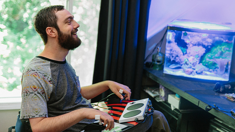 Spencer uses the Xbox Adaptive Controller to play a game.