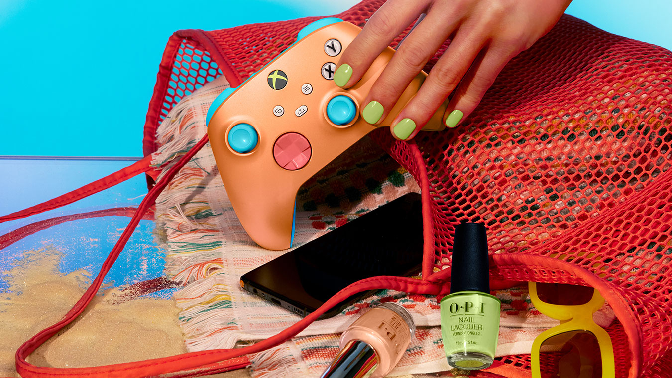 update main gallery with image: A mão em uma bolsa de praia para segurar o Controle Sem Fio Xbox – Sunkissed Vibes OPI Edição Especial entre, celular, óculos de sol e esmalte de unha.