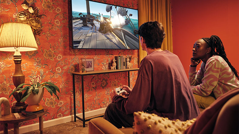 Twee mensen in een woonkamer spelen Xbox op een Samsung smart-tv