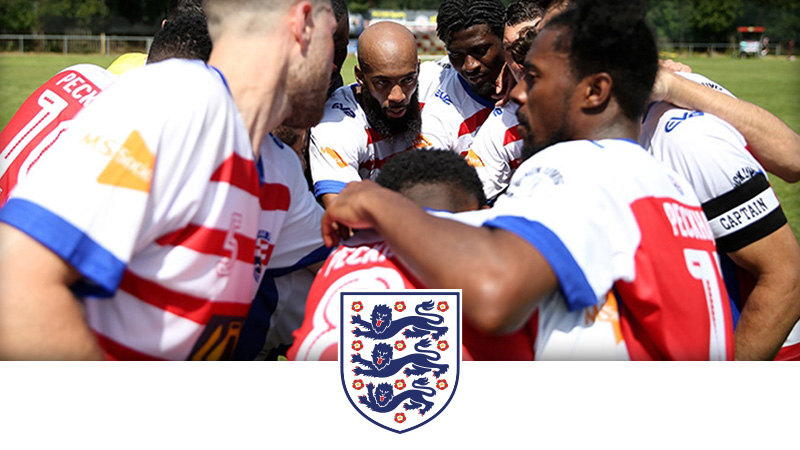 A group of football players, huddled in a circle, having a team discussion