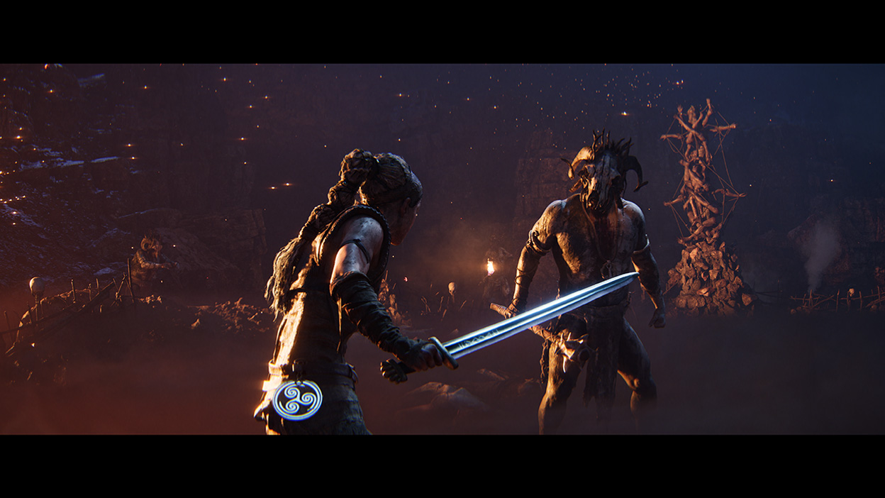 Senua drží vytasený meč a je pripravená bojovať s nepriateľom, ktorý stojí pred ňou.