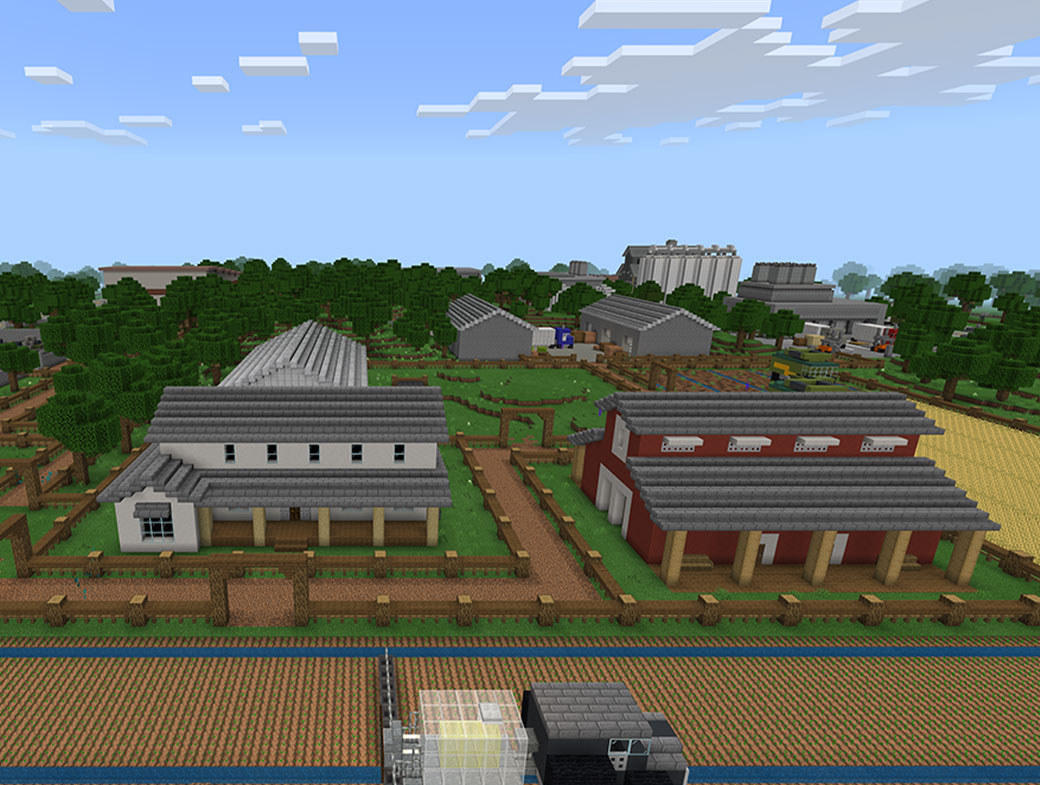 Minecraft: Education Edition. Κτίρια που είναι διάσπαρτα ανάμεσα σε δασικά κομμάτια και χωμάτινα μονοπάτια. Ένα φορτηγό που μεταφέρει υλικά σταματά μπροστά από δυο κτίρια.