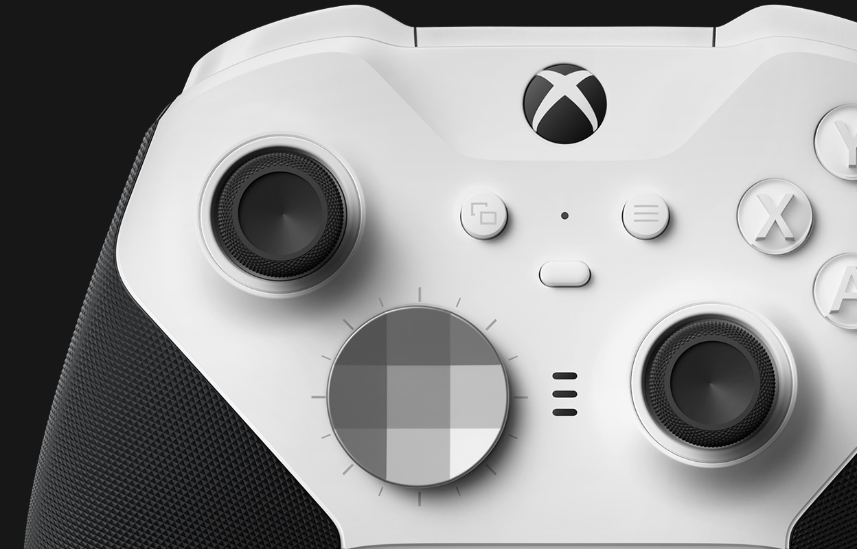 Blízký pohled na bezdrátový ovladač Xbox Elite Series 2 – Core (bílý), zobrazující podrobné zobrazení kompletně pogumované rukojeti a palcových ovladačů.