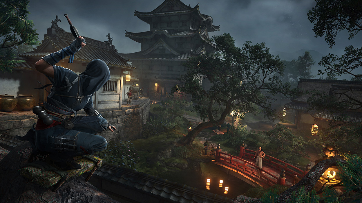 Naoe, de pé em um telhado e envolta em escuridão, se prepara para atacar inimigos em uma ponte abaixo.