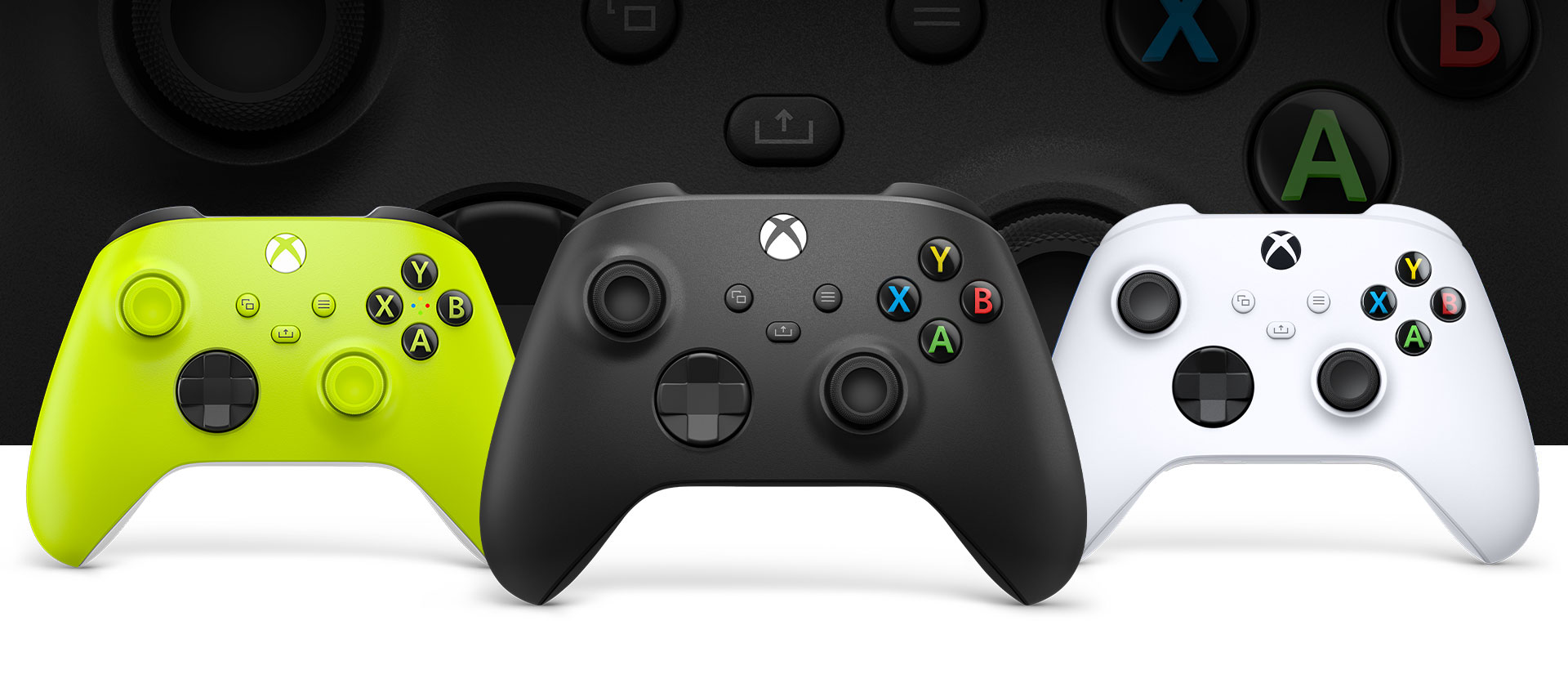 Геймпад Xbox черного цвета Carbon Black на переднем плане, зеленого — слева и белого Robot White — справа