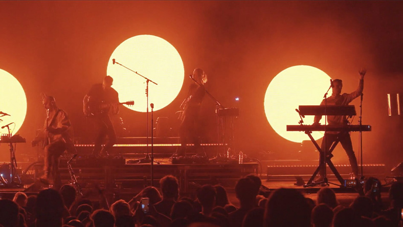 The X Ambassadors perform on stage in front of a crowd.