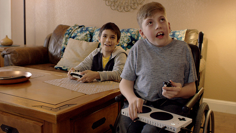 Owen uses the Xbox Adaptive Controller to play a game with his friend.