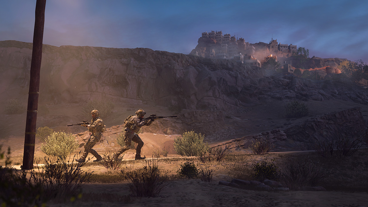 Δύο χειριστές προχωρούν προσεκτικά μέσα σε ερημικούς πρόποδες της ερήμου στο Call of Duty: Modern Warfare II.