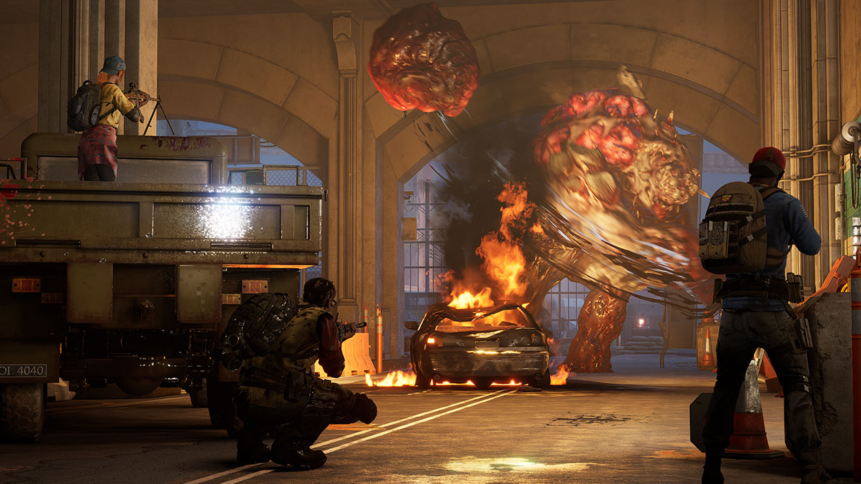 Players battle and shoot a giant zombie monster in a parking garage.