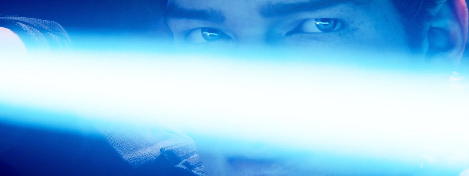 En närbild på Cal Kestis som håller ett lasersvärd framför sitt ansikte