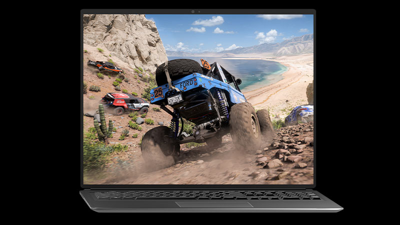 『Forza Horizon 5』のオフロード車が丘陵を海岸に向かって下っているのがラップトップに表示されている。