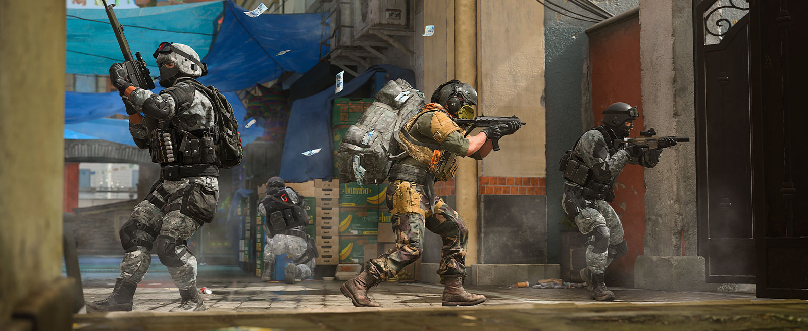 Four Operators advance towards a gate under the cover of an empty street market.