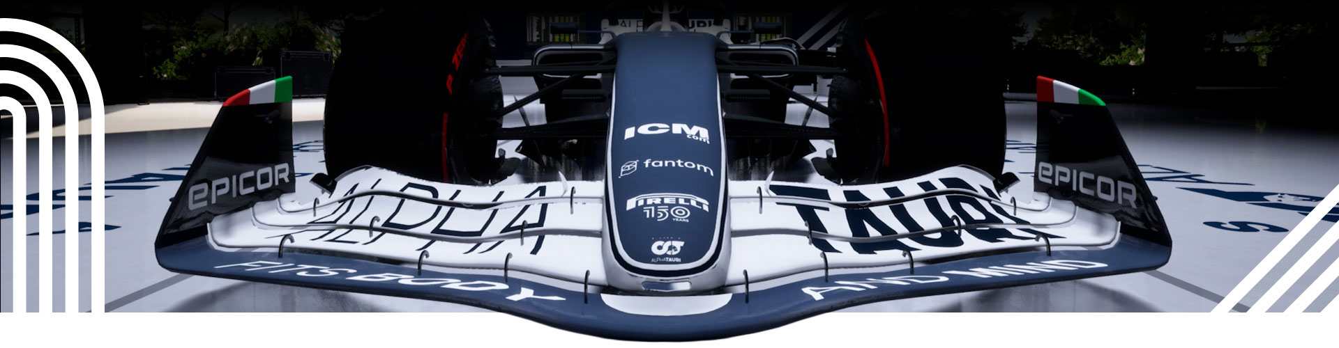 Motiv závodního pruhu se zaparkovaným vozem F1 v pozadí.